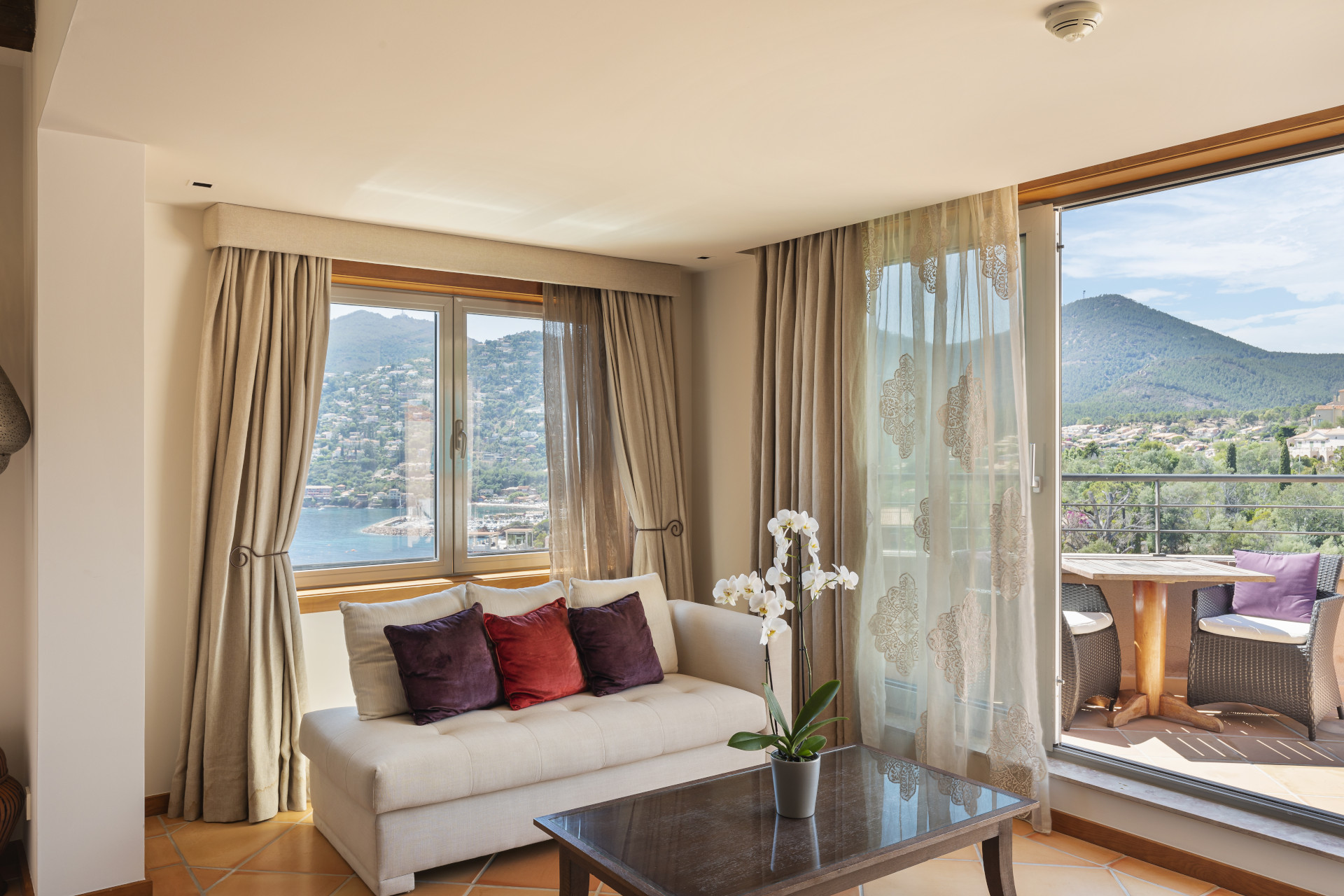 Salon avec vue panoramique sur la mer et les collines depuis la suite du Tiara Miramar Beach Resort à Théoule-sur-Mer, Côte d’Azur