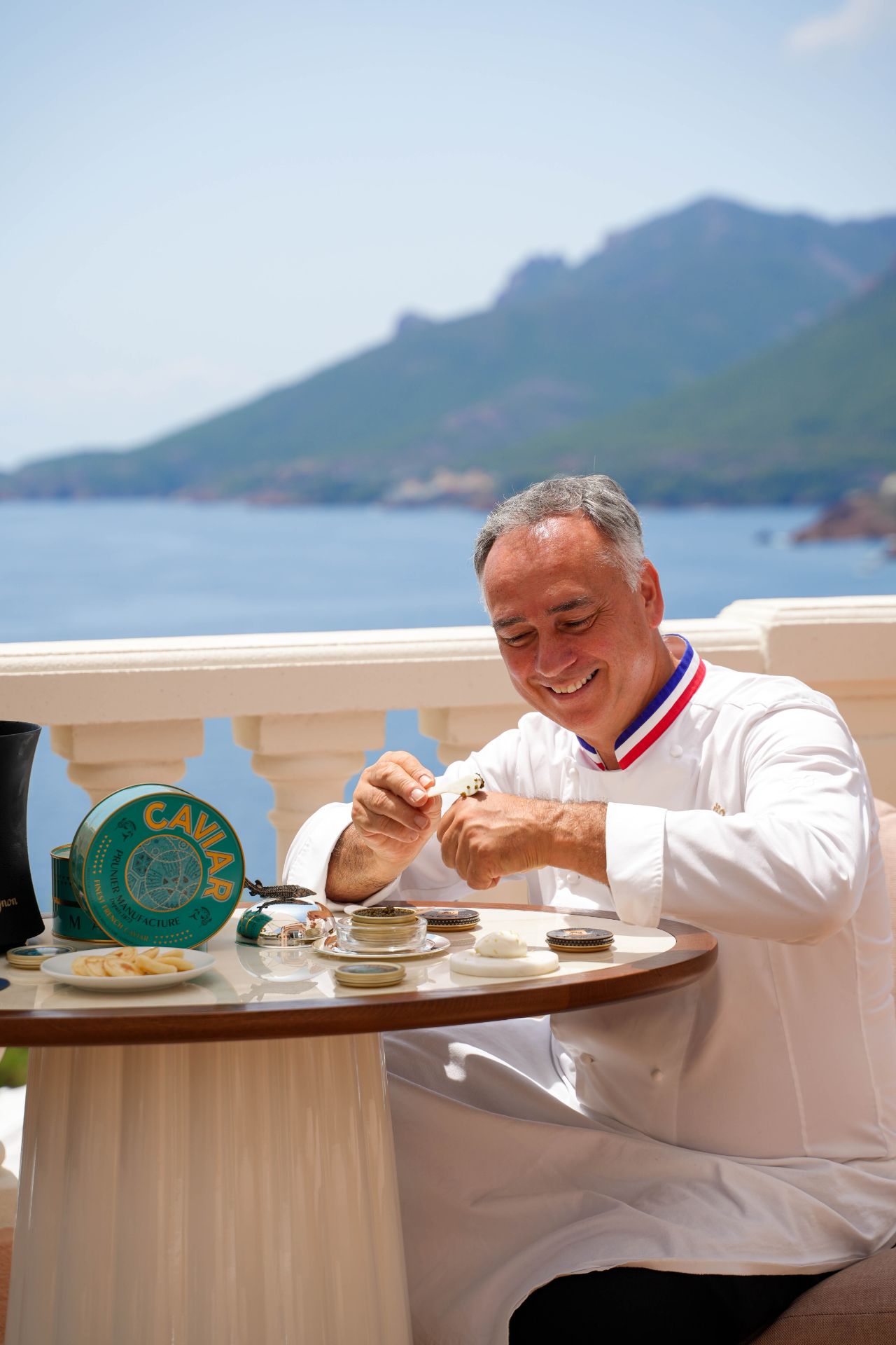 Le Chef Meilleur Ouvrier de France dégustant du caviar Prunier à la cuillère de nacre en terrasse face à la Méditerranée, Yaktsa Lounge by Prunier, Tiara Miramar Beach Resort